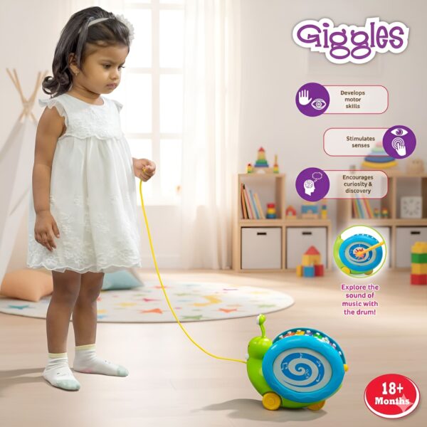 Little girl pulling Funskool Giggles Musical Snail toy on floor