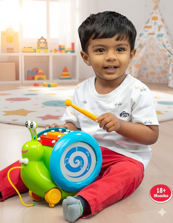 Toddler playing with Funskool Giggles Musical Snail toy indoors